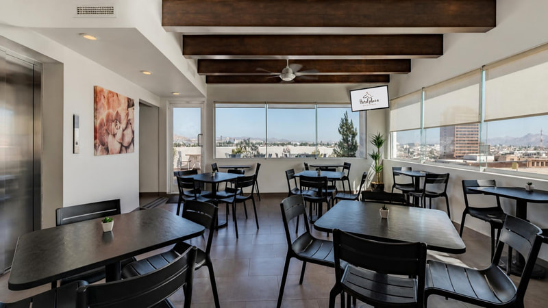 Comedor del hotel con ventanales y vistas a la ciudad